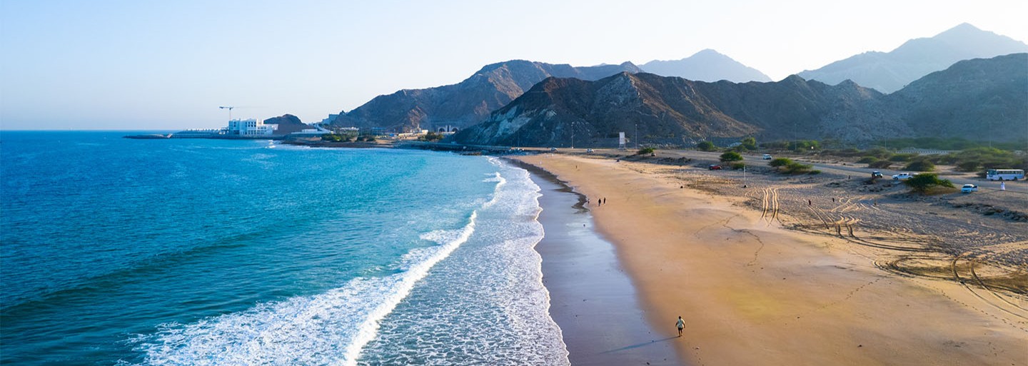 Fujairah beach with Al Hajar mountains and historic fort